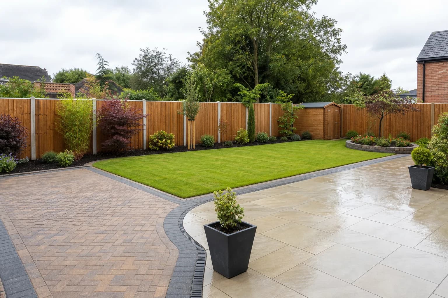 A professionally landscaped garden showing paving, fencing and a tidy lawn