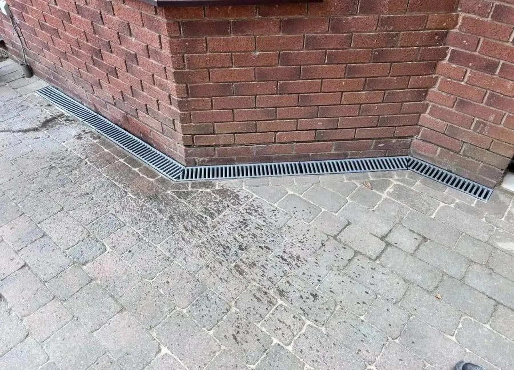 Drainage channel laid along the base of a brick wall as part of groundworks